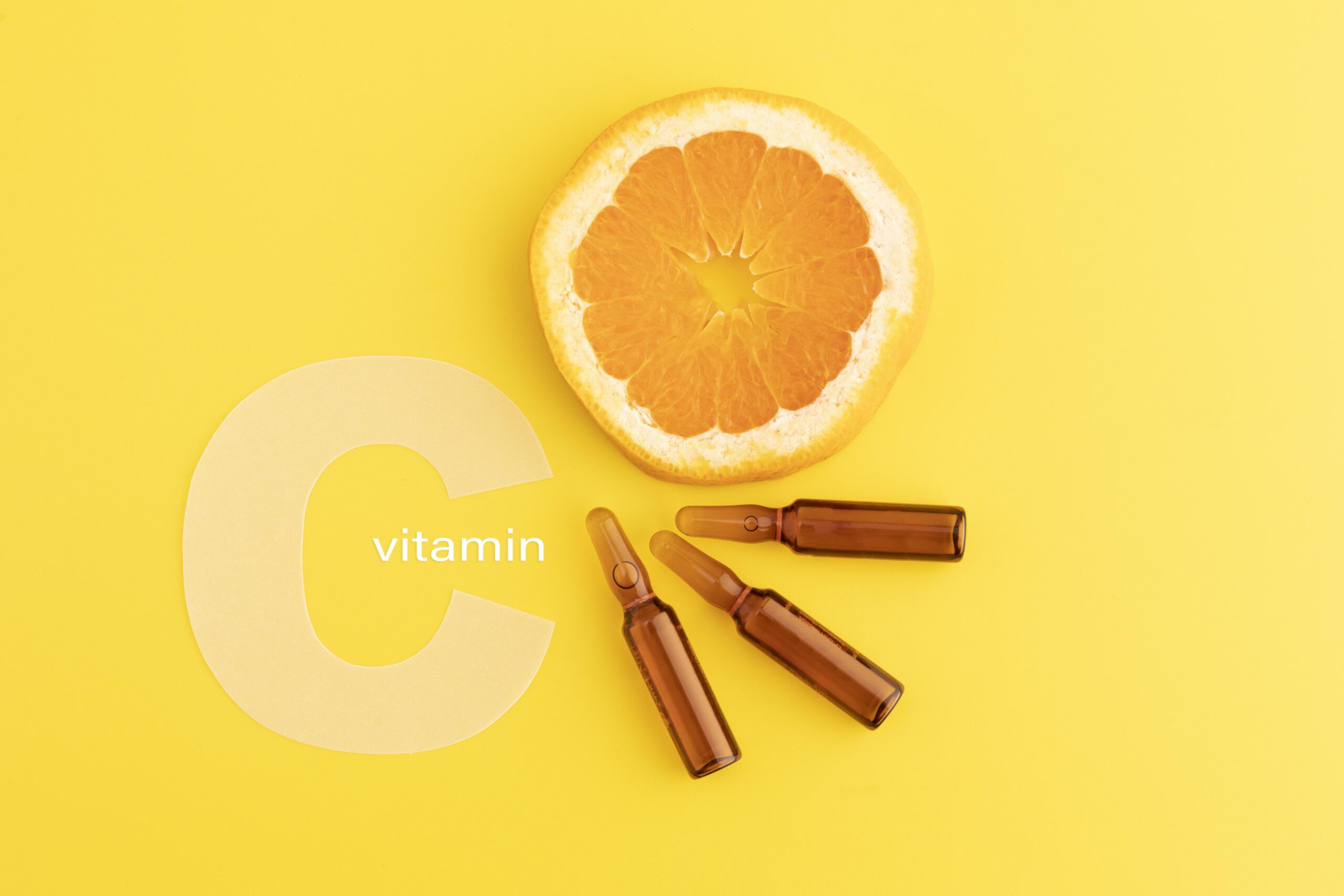 close up of vitamin c serums with an orange slice