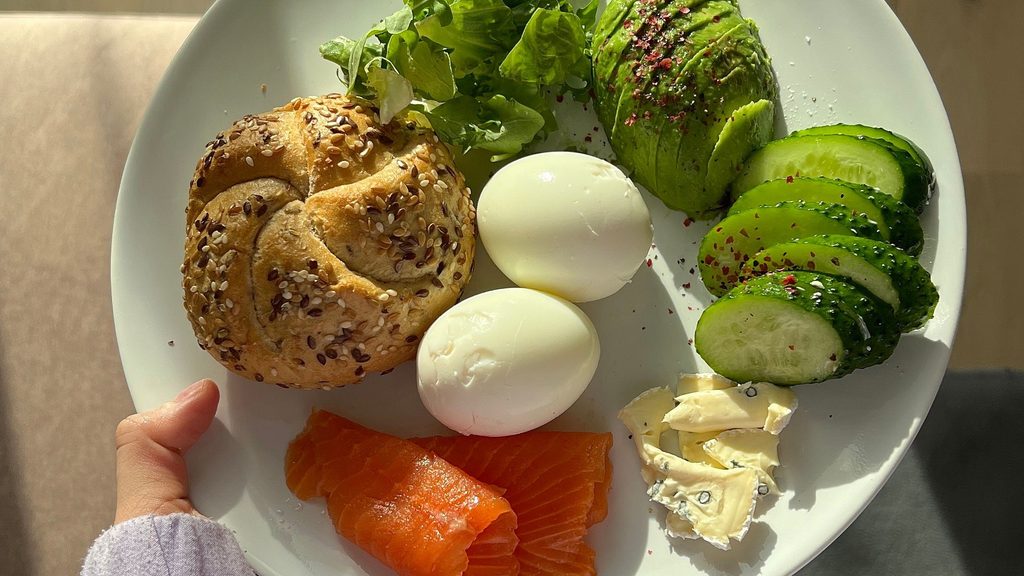 A person holding a plate of balanced meal