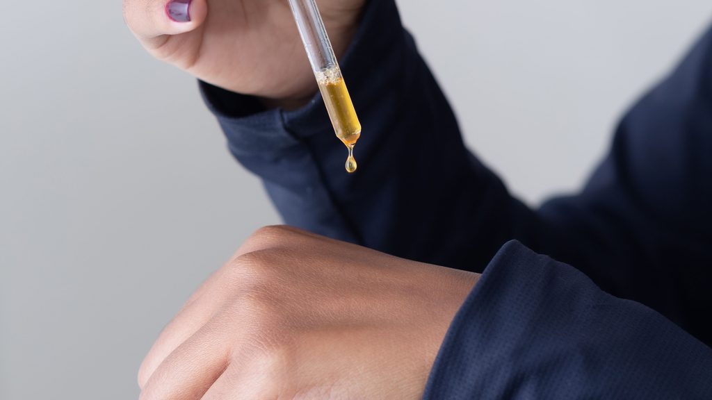 close up of a vitamin c serum drops on woman's hand