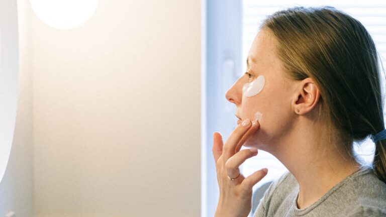 A woman doing skincare; moisturizing her skin